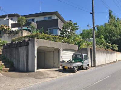 生垣で囲われた施工前の車庫と擁壁