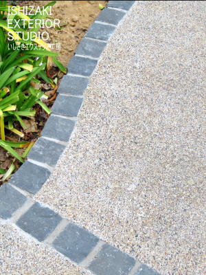 黒のピンコロ石で縁取りしたベージュの樹脂舗装