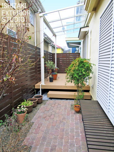 テラス屋根×デッキ×目隠しフェンス、レンガ風舗装でナチュラルガーデンに